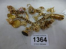 A 9ct gold charm bracelet with 17 charms including Victorian sovereign (130 grammes)