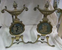 A pair of Victorian brass fire dogs with Wedgwood plaques (one a/f)
