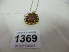 A 9ct gold pendant set red stone