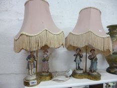 A pair of porcelain figure table lamps with shades