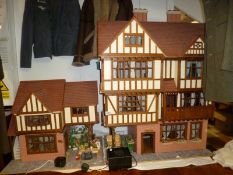 A large Elizabethan style doll's house and florist shop complete with furniture and fittings