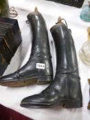 A pair of vintage leather riding boots with wooden inserts