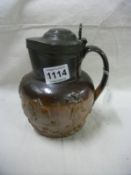 A stoneware harvest jug with pewter lid