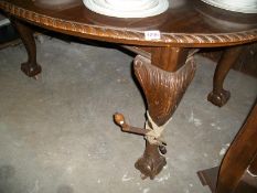 An extending wind out dining table with 2 leaves and handle