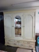A painted 3 door wardrobe with drawer base