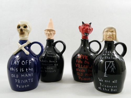 4 Old Man`s Poison decanters with skull, Devil, an witch and judge stoppers. 25cm tall.