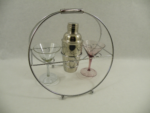 A chrome Art Deco style cocktail shaker and two cocktail glasses mounted in a chrome circular