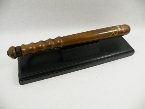 A mid to late 20th C police presentation truncheon, mounted on an ebonised plinth, the truncheon