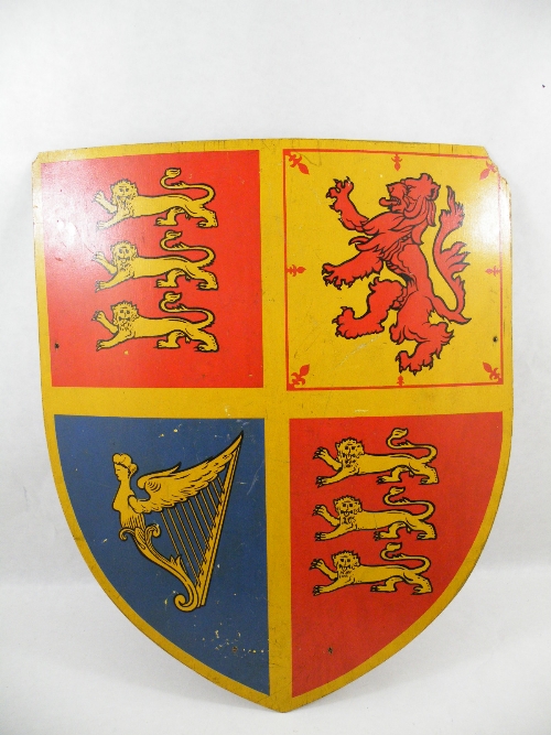 A painted wood shield, reputed to have been used as a wall decoration at the celebration of George V