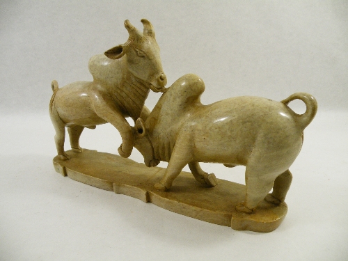 A pair of African carved soapstone fighting bulls 34cm long