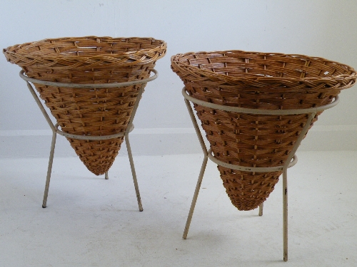 A pair of 1950s style wrought and painted metal planters on tripod legs supporting woven basket