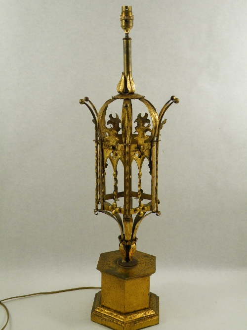 A wrought gilt metal table lamp mounted on a hexagonal gilt metal base, the central section formed