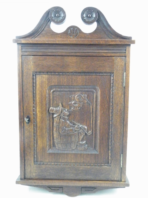 Early 20th Century oak Scottish smokers cabinet with carved door of gentleman with pipe and with