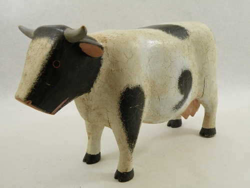 A carved wooden Frisian cow model with cracked painted finish - possibly a Butcher`s shop window