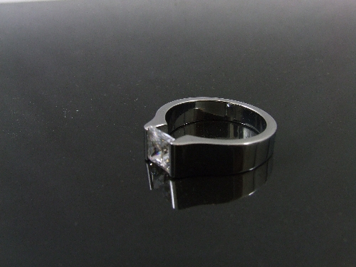 A ladies steel contemporary dress ring - the centre mounted with a large princess gut cubic