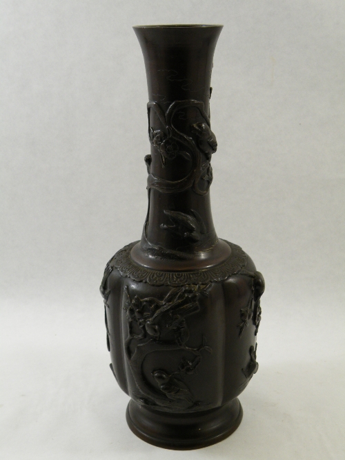 A Japanese brown patinated bronze bottle vase, Meiji period, the shoulder and neck profusely