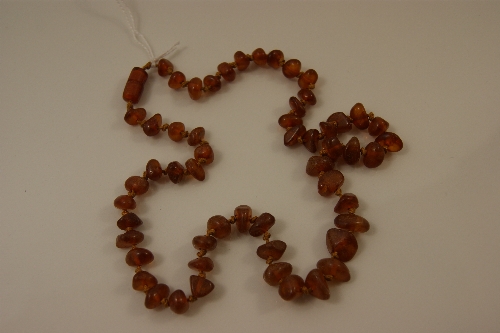 A Baltic amber necklace on hand knotted stringing and amber coloured fastening 44cm long &  Baltic