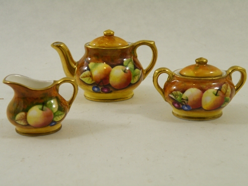 A Coalport miniature hand painted tea set by Manfred Pinter with assorted fruit with gilt