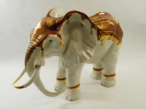 An impressive early 20th C porcelain model of an elephant with painted and gilded decoration  as a