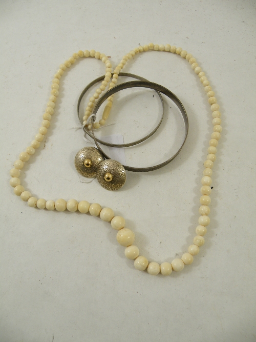 1920s graduated ivory bead necklace, two silver bright cut bangles and two ear studs of shield form