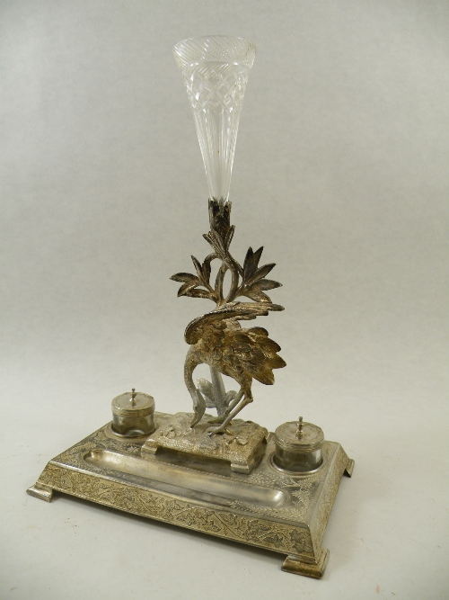 A Victorian silvered metal desk stand with covered glass inkwells, pen recess and central epergne