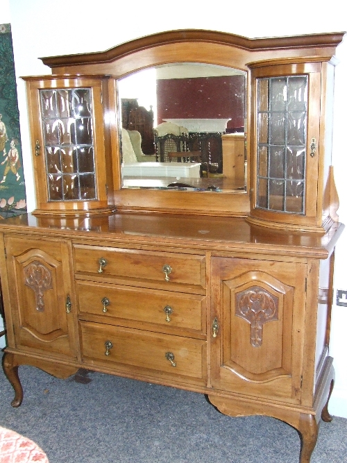 A Victorian walnut dresser of Art Nouveau influence the dresser back with bow front leaded and