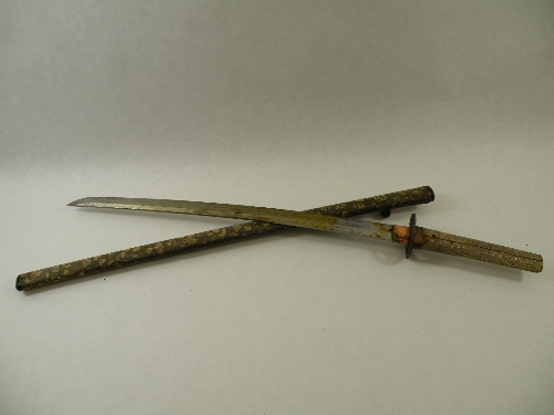 A shagreen handled Japanese Wakizashi with a curved blade, iron pierced tsuba and a decorated