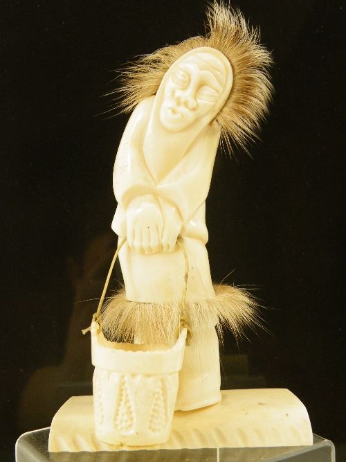 Inuit marine ivory and bone carved figure ice fishing with carved bucket on gut string - the