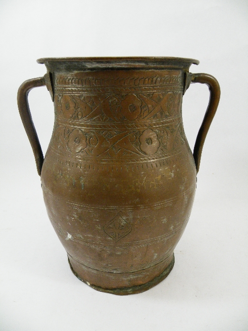 A Large twin handled Eastern copper vase or water carrier with repeat hammered decoration of