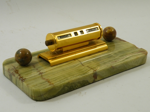 An early 20th C Art Deco period brass-cased perpetual desk calendar mounted on a Brazilian onyx base