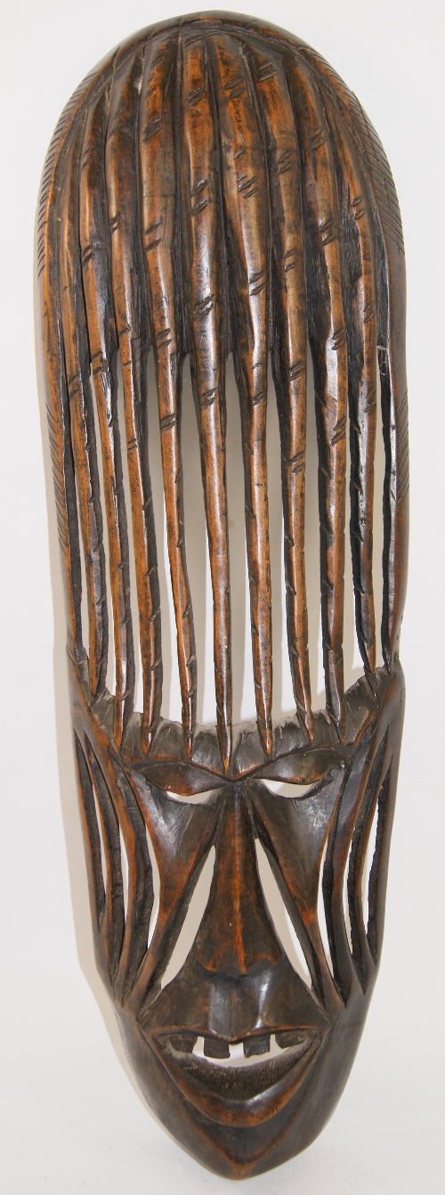 A 20th C African carved wooden face mask of elongated form. 61cm high