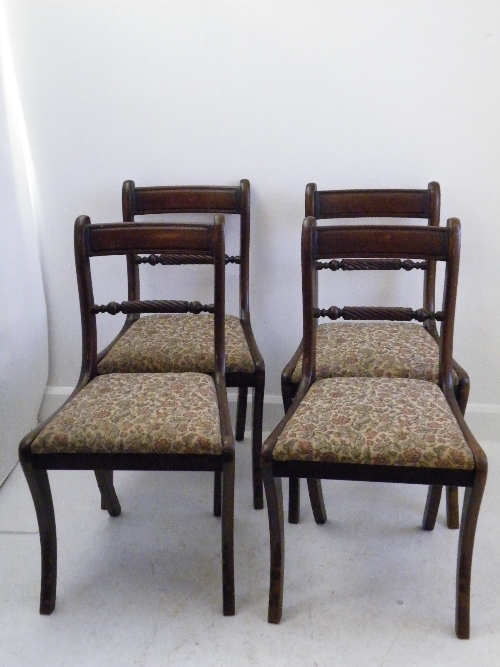 A set of four Regency style mahogany dining chairs with rope twist backs and sabre legs