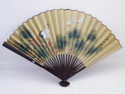 A large early 20th C Japanese bamboo fan decorated with birds flying through the tree tops 90cm