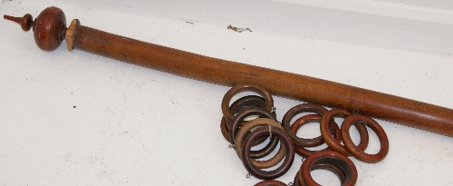 A Victorian mahogany and fruitwood curtain pole with turned end finials, rings and mounting brackets