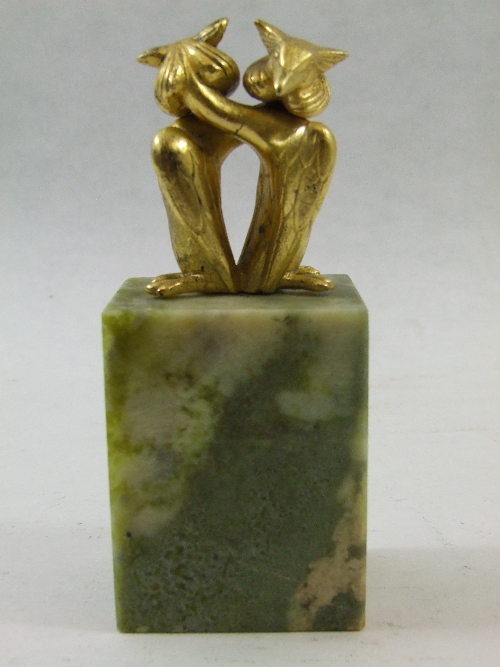 A small desk paperweight of two entwined gilt great crested grebe  birds on a green marble base,