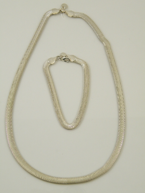 An unusual suite of silver jewellery comprising articulated flat link necklace and matching bracelet