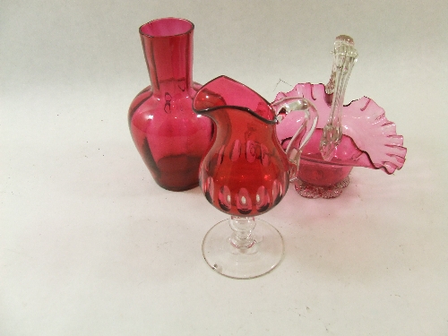 Three pieces of cranberry glass, a fluted bowl, a footed jug and a small vase - all approx 16cm high