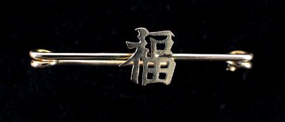 An oriental motif, fitted to a safety pin style bar brooch, stamped 15ct on pin. VGC Plate 6