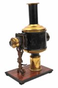 A Magic Lantern. A brass example mounted on a wood stand. The tank for the liquid fuel (oil or
