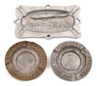 A collection of 3 alloy ash trays. 2 circular examples 10.5cm both marked ‘cast from strafed