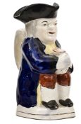 A Staffordshire Toby jug of traditional form, holding an ale jug, handle on reverse, 7¾” high, GC