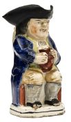 A Staffordshire Toby jug of traditional form, holding an ale jug, handle on reverse, 9½” high, GC (