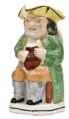 A Staffordshire Toby jug of traditional form, holding an ale jug, handle on reverse, 9” high, GC