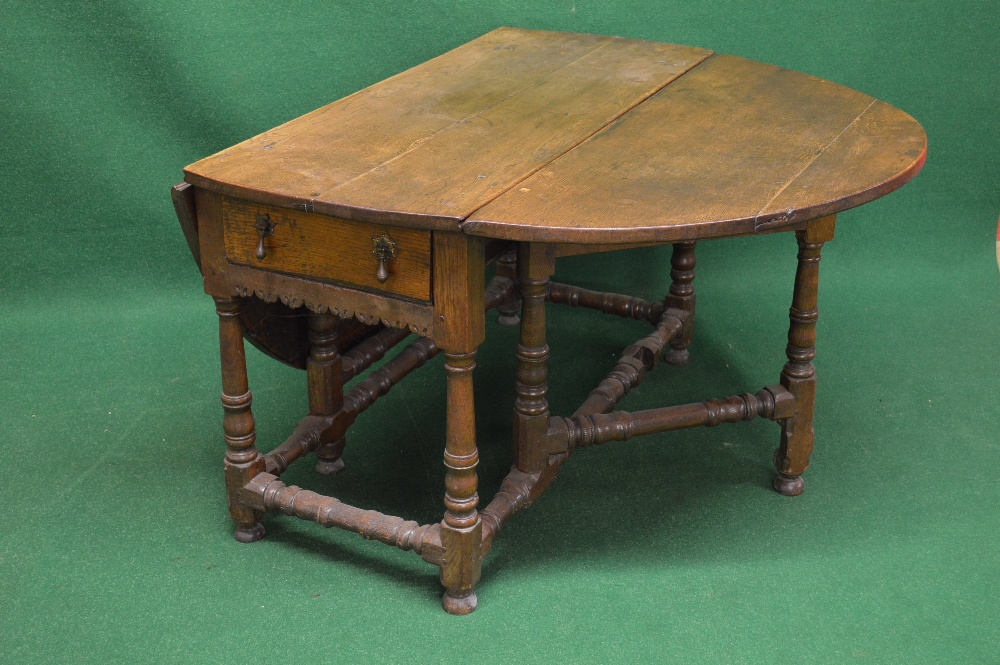 An 18th century  oak oval drop leaf gateleg table with bow ends over two drawers with drop handles