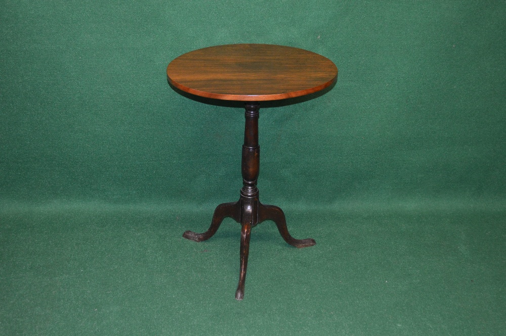 A circular mahogany tip top occasional table, the top supported by turned column leading down to