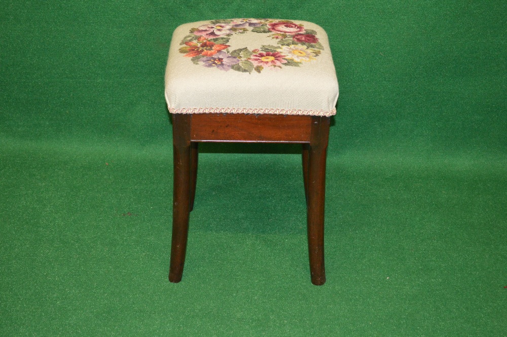 A mahogany dressing stool with floral embroidered seat, standing on swept legs