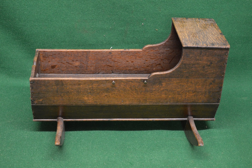 A 19th century oak cradle having raised head canopy and shaped foot end - 35" long