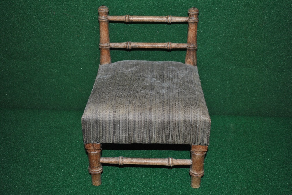 A small childs chair having faux bamboo form with padded seat