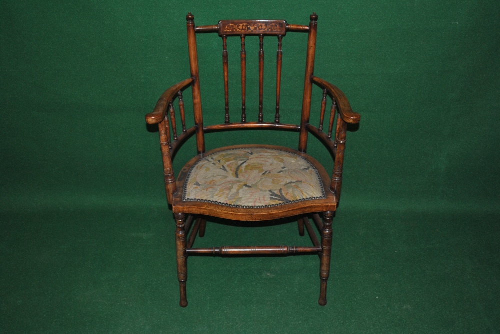 An inlaid spindle back elbow chair with shaped embroidered seat, turned stretcher and turned front