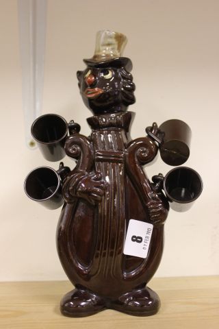 A Ceramic Decanter in the form of Minstrel with four cups